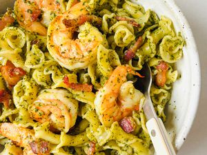 Shrimp pasta with pesto and a fork in a bowl