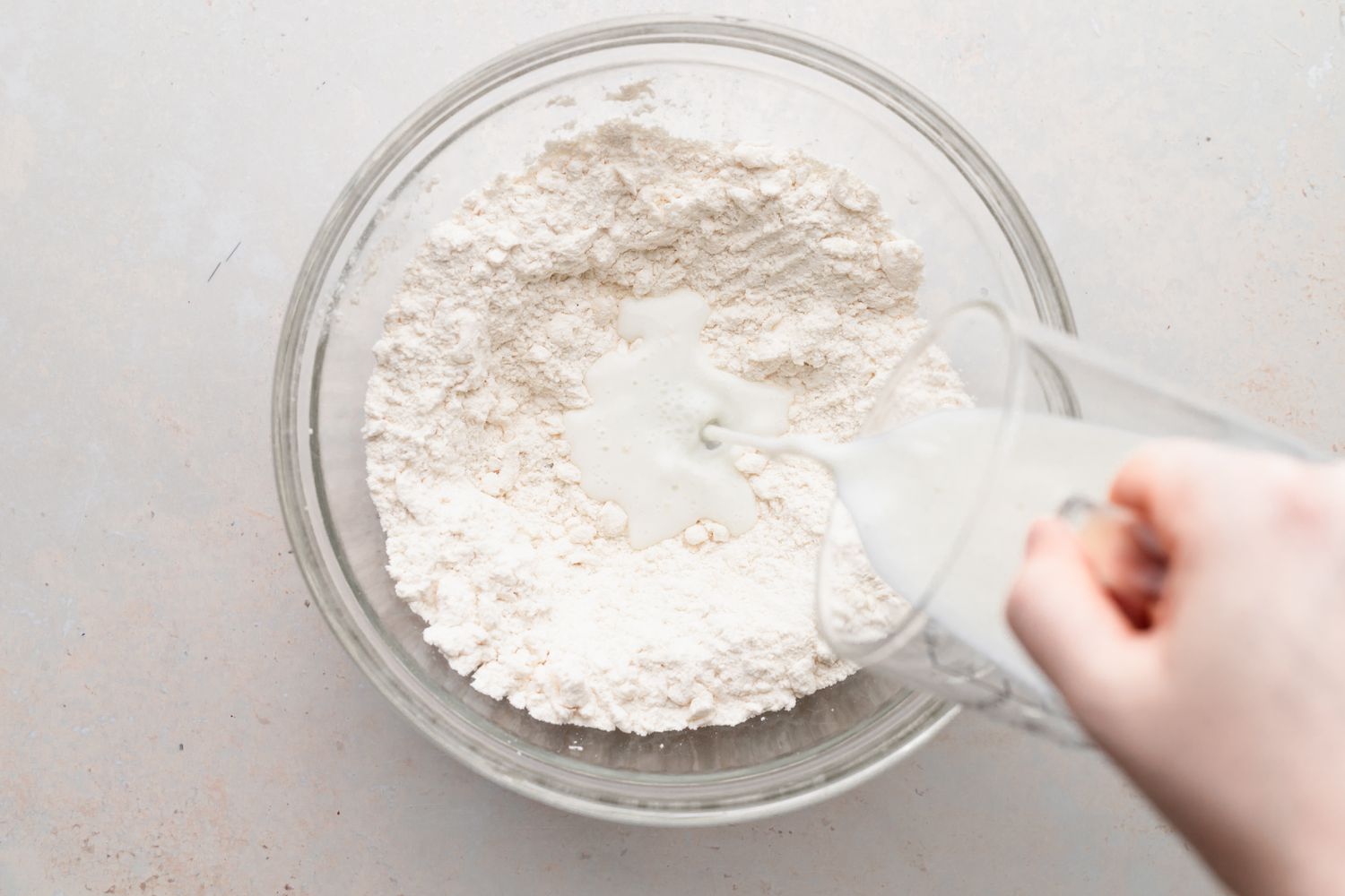 Making biscuits in a glass bowl for a biscuits and gravy recipe.