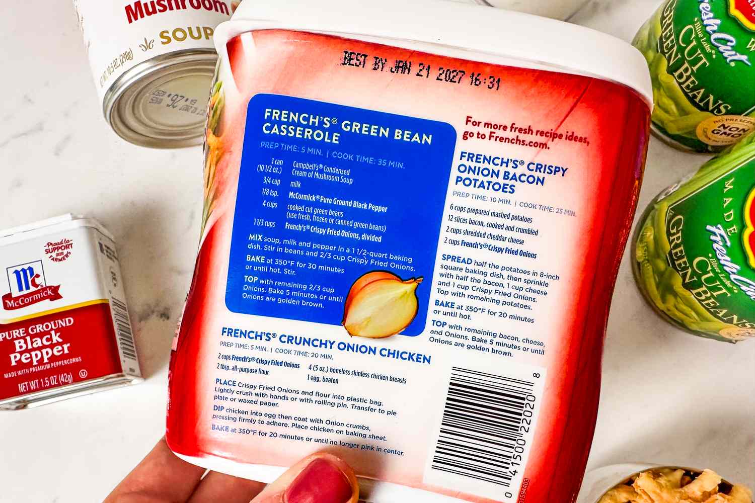 A Frenchs container with a printed recipe for green bean casserole surrounded by other cooking ingredients