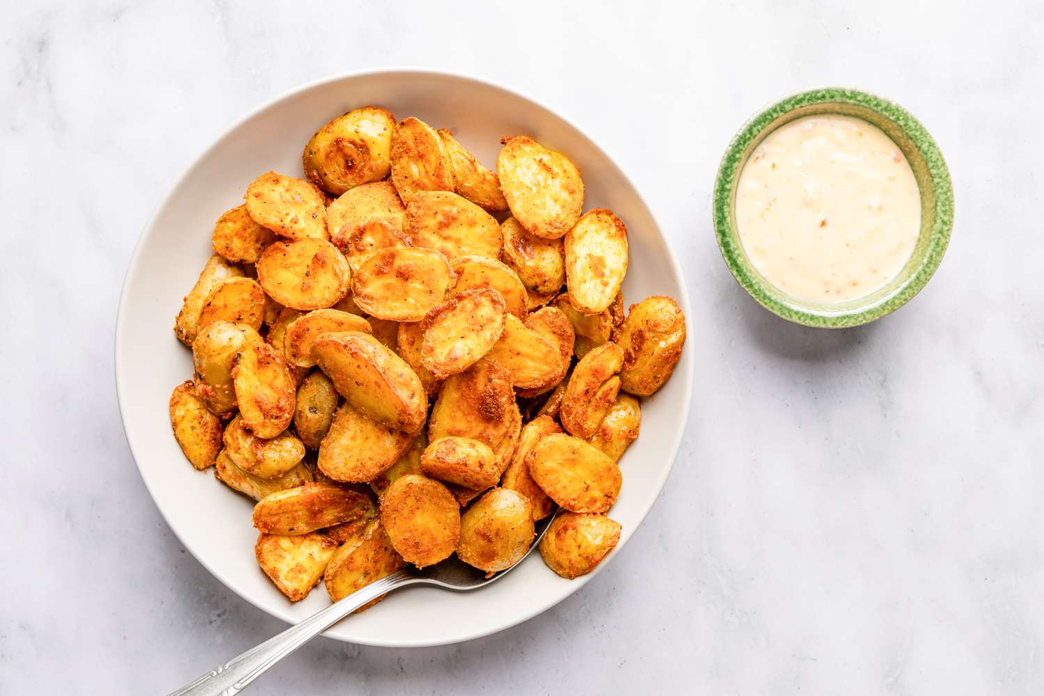 bowl of bang bang potatoes and a bowl of bang bang sauce