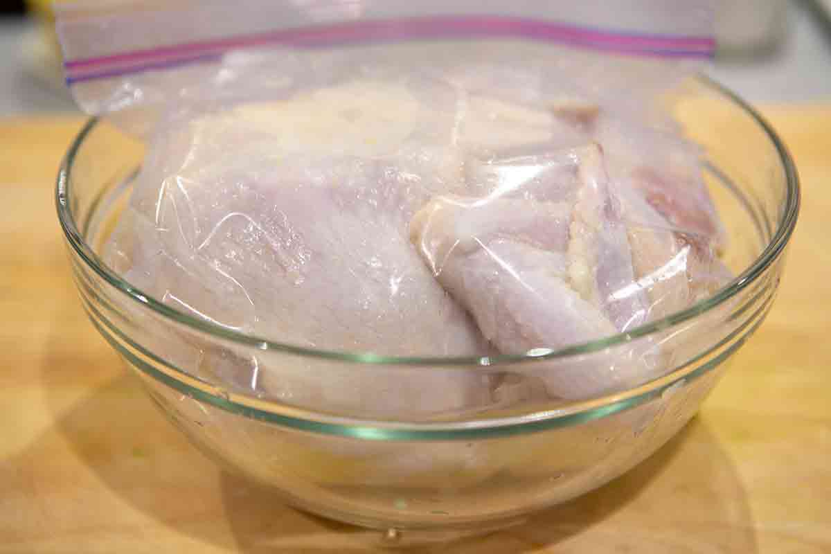 marinating whole chicken in lemon juice in a zipper top bag