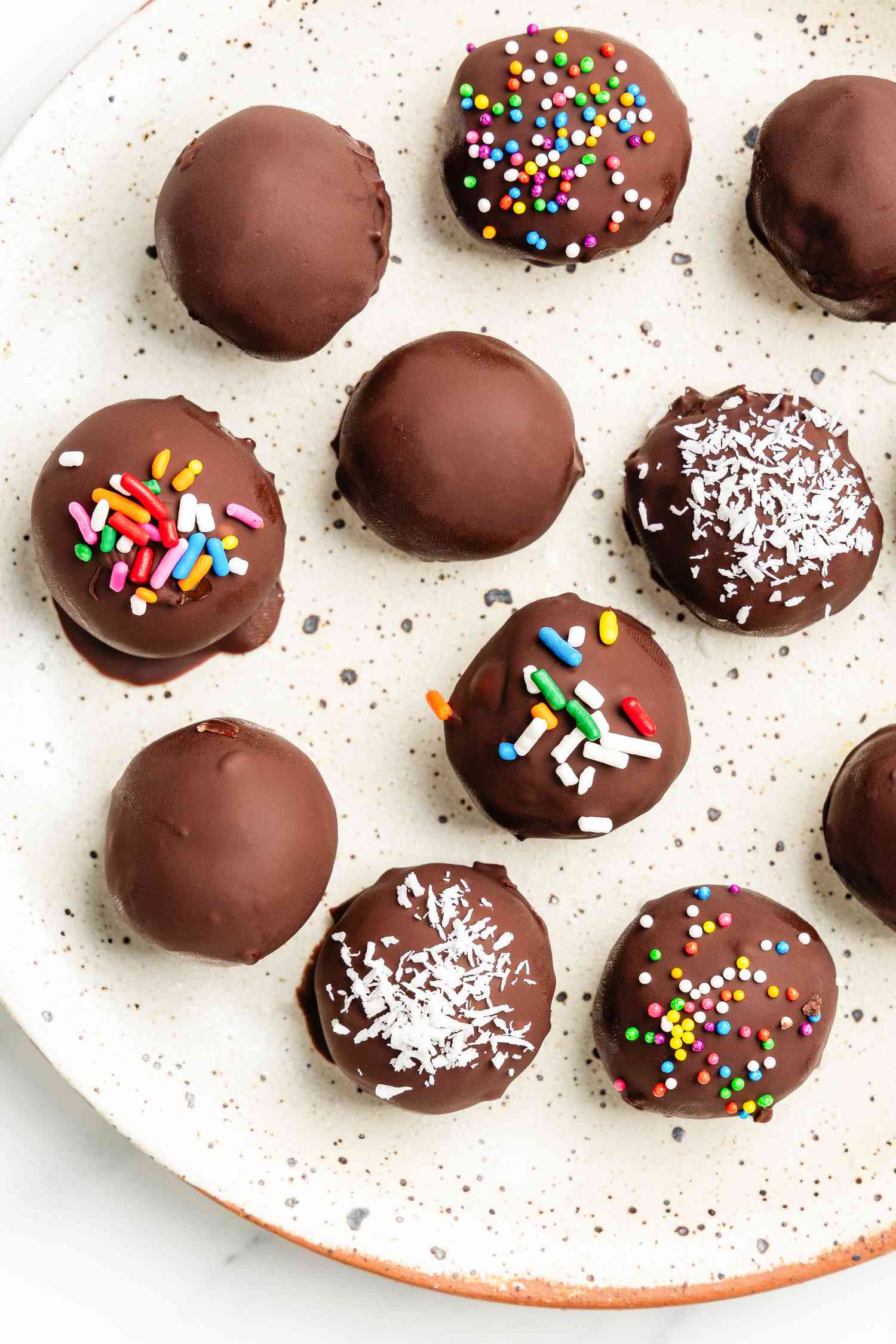 Potato candy (some with toppings, some just covered in chocolate) on a plate