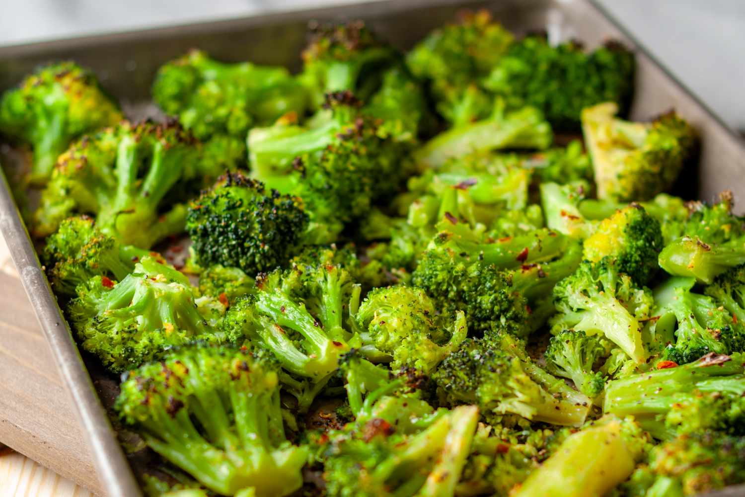 Roasted broccoli florets arranged on a baking sheet