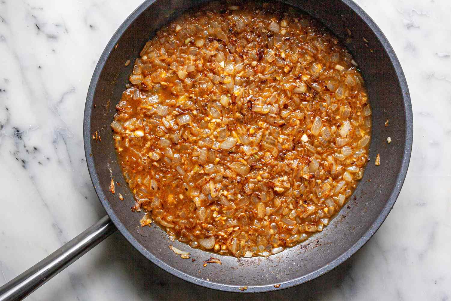 Flour spice mixture and cooked aromatics in a skillet for an easy smothered chicken and gravy recipe.