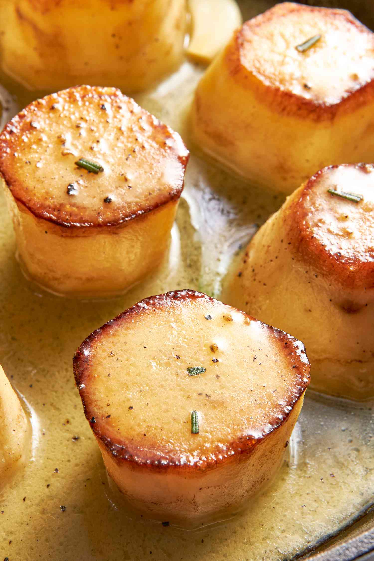 Close-up: fondant potatoes on a cast iron skillet