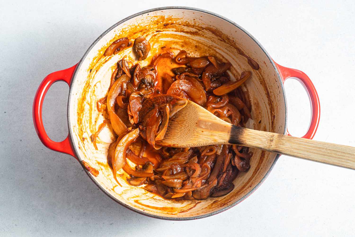Dutch Oven with Caramelized Onions Mixed with a Wooden Spoon for How to Deglaze a Pan