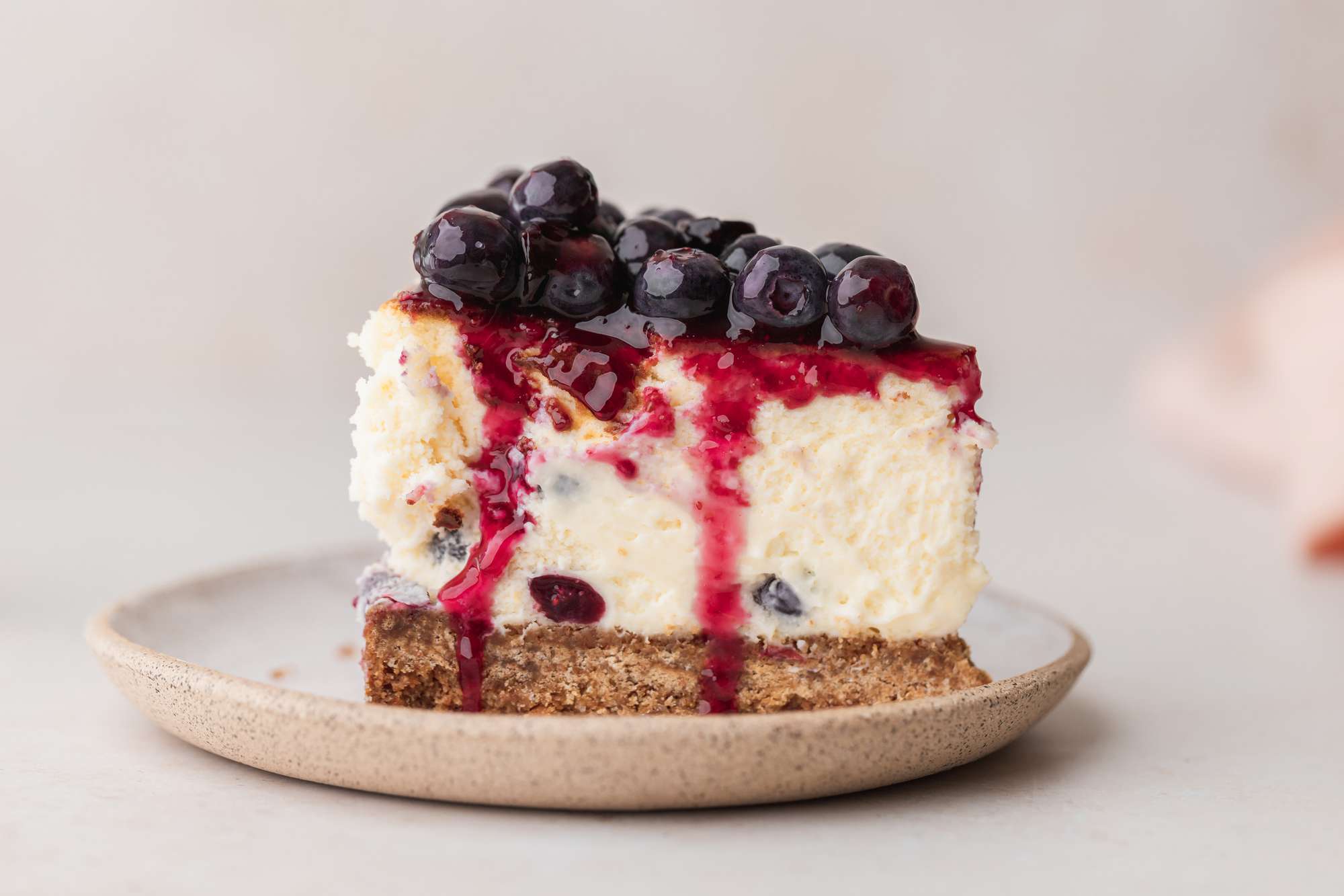 A slice of blueberry cheesecake on a plate.