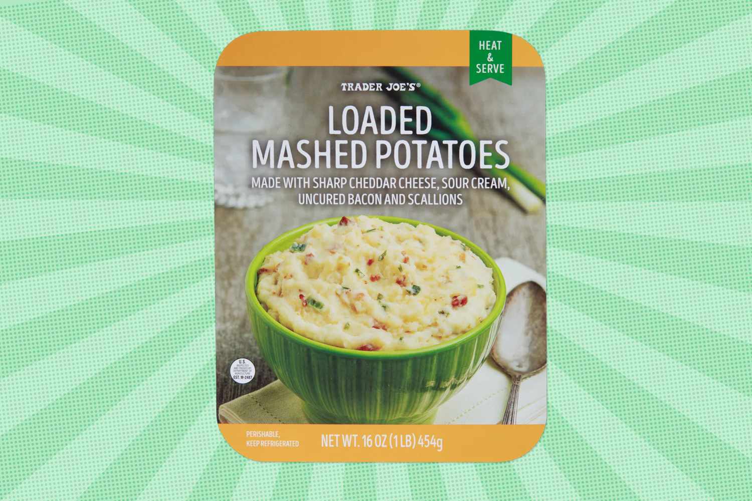 A package of Trader Joes Loaded Mashed Potatoes displaying the product in a green bowl highlighted on a textured green background