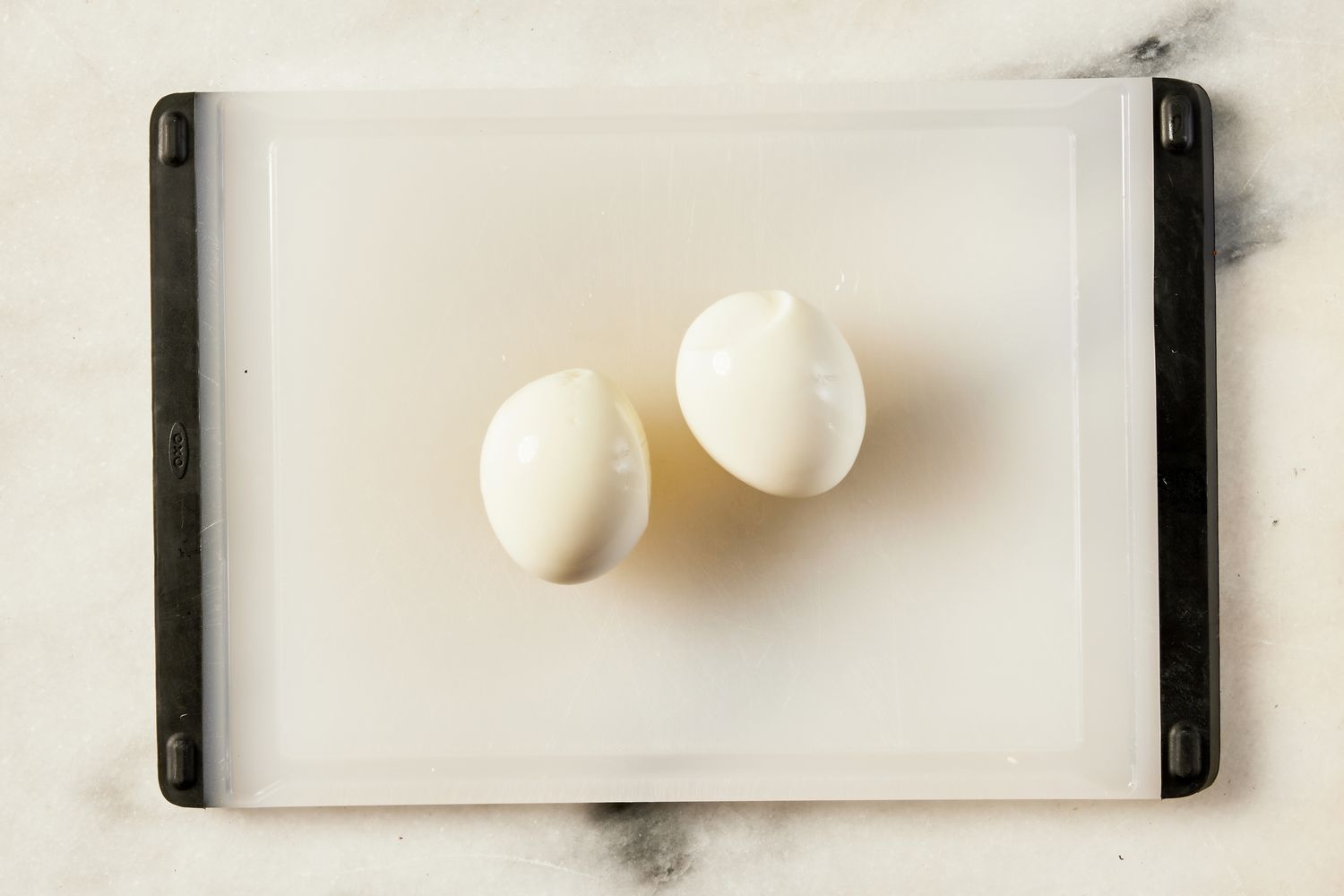 peeled hard boiled eggs on a cutting board for Korean-style potato salad recipe