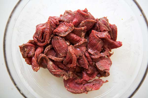 beef being marinated in glass bowl for beef broccoli