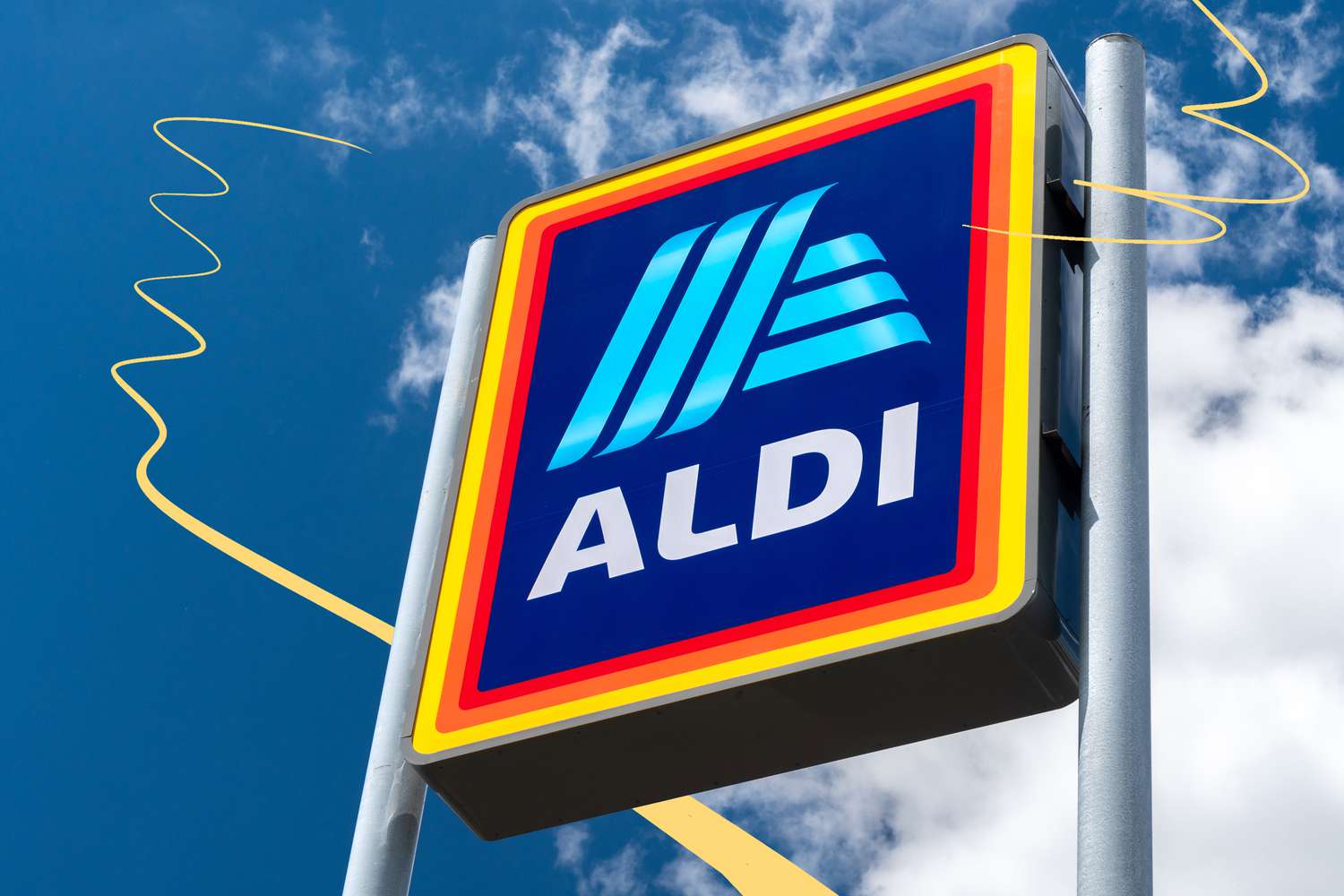 A large ALDI logo sign mounted on a pole against a blue sky background