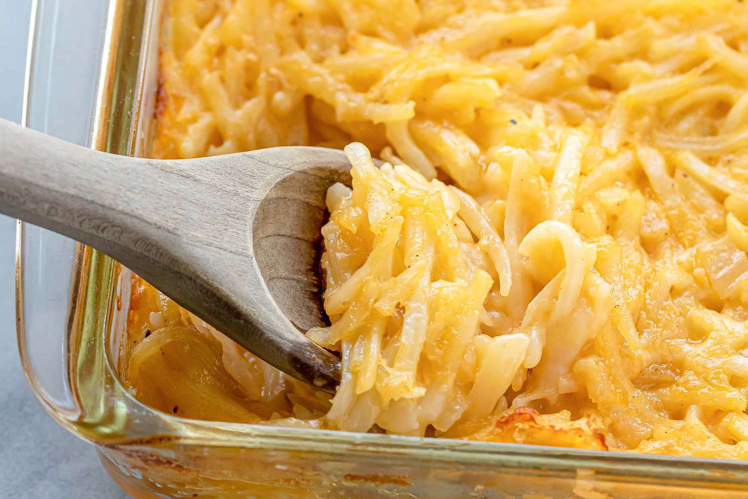 Cheesy Potato Casserole in a dish with a serving spoon