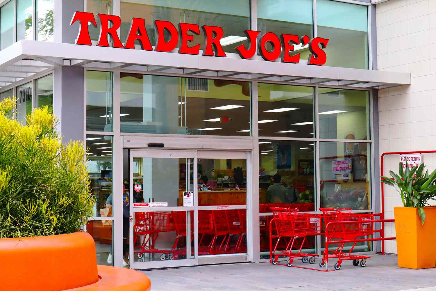 Trader Joe's store entrance with shopping carts outside, glass facade