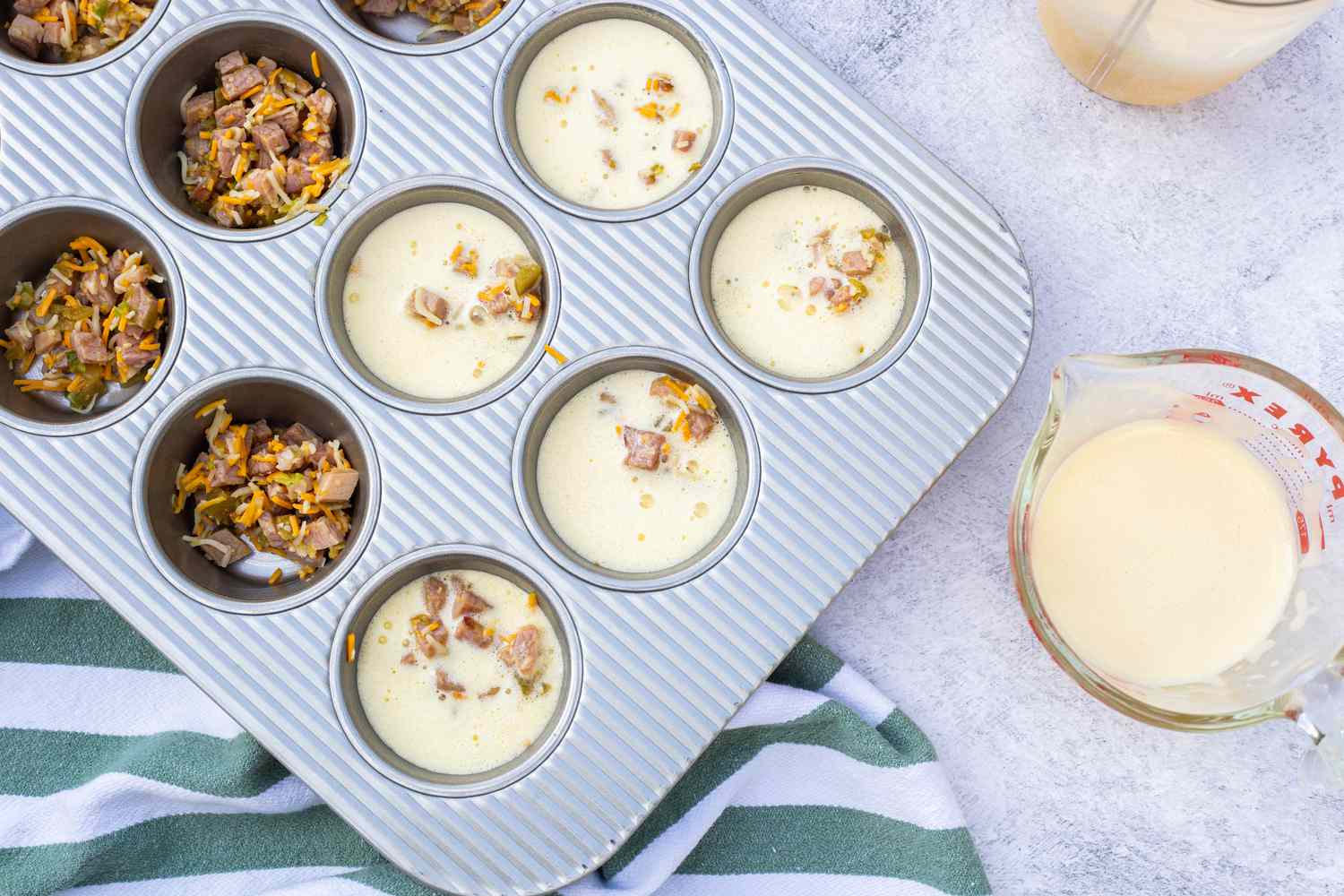 Muffin Tin Filled with Ham, Cheddar, and Green Chile Mixture and Egg Bites Mixture