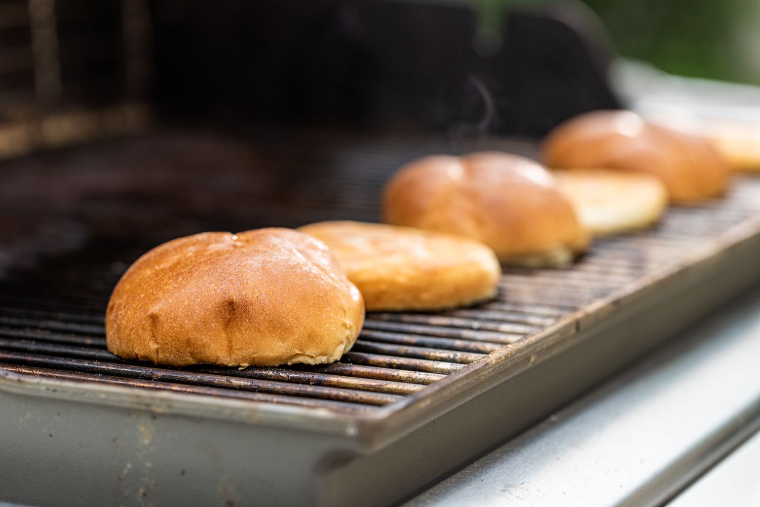 Toasting buns on a grill for the best bacon cheeseburger