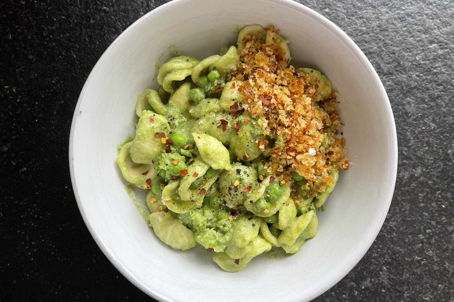 A bowl of orecchiette pasta with green sauce and breadcrumbs