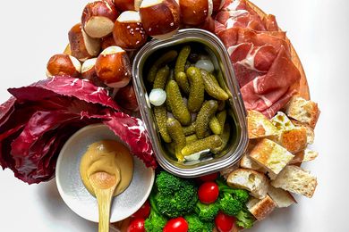 Overhead view of a tray of various foods to dip in cheese fondue