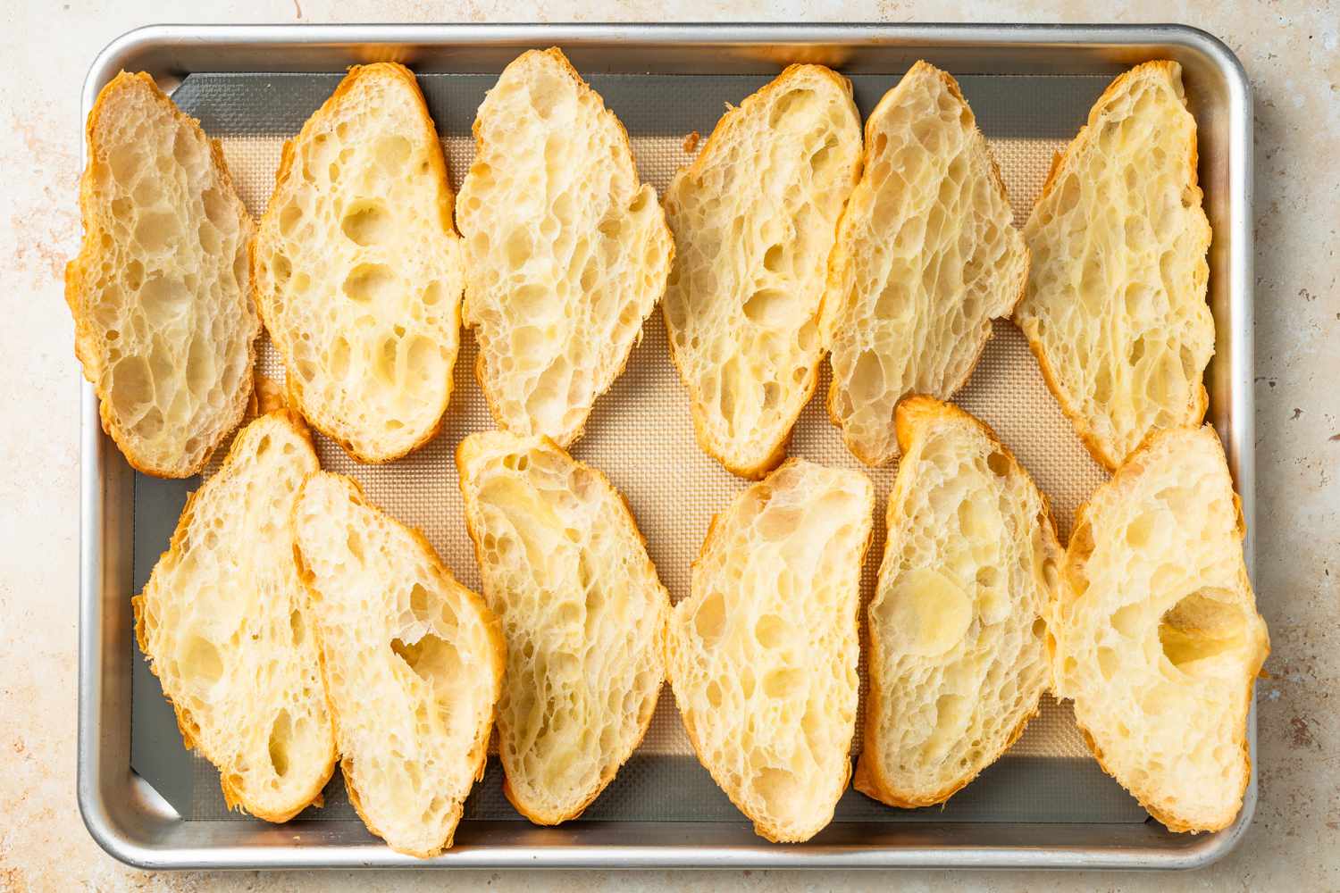 Halved Croissants on a Silicone Baking Mat Lined Baking Sheet