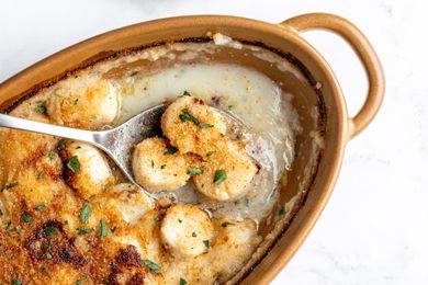 Bakes scallops in a creamy sauce served from a baking dish