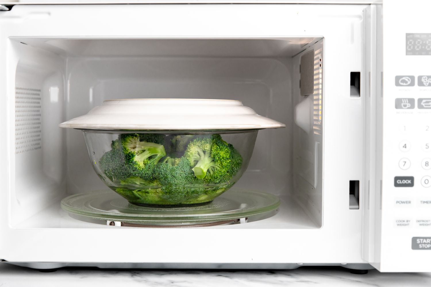 Bowl of Broccoli Florets Covered with a Microwave Safe Plate for Steamed Broccoli Recipe 