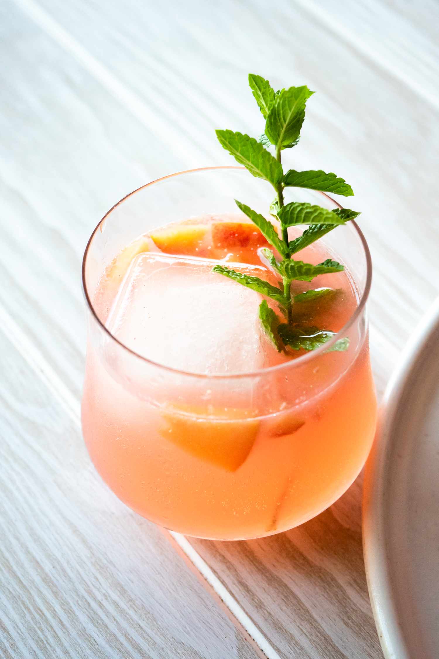 Glass of Ginger Peach Rum Punch with a Sprig of Mint