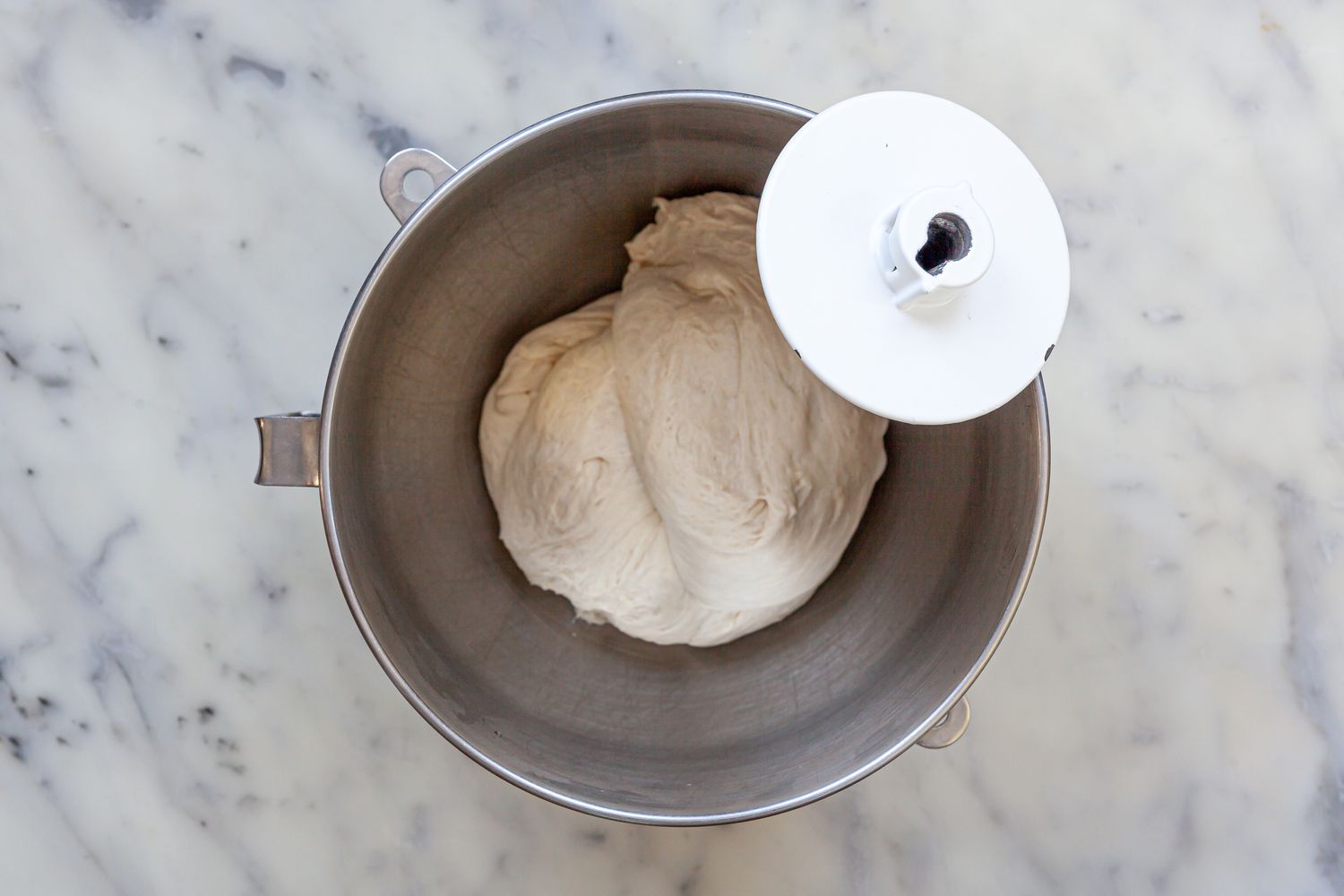 Homemade pizza dough kneaded in a stand mixer.