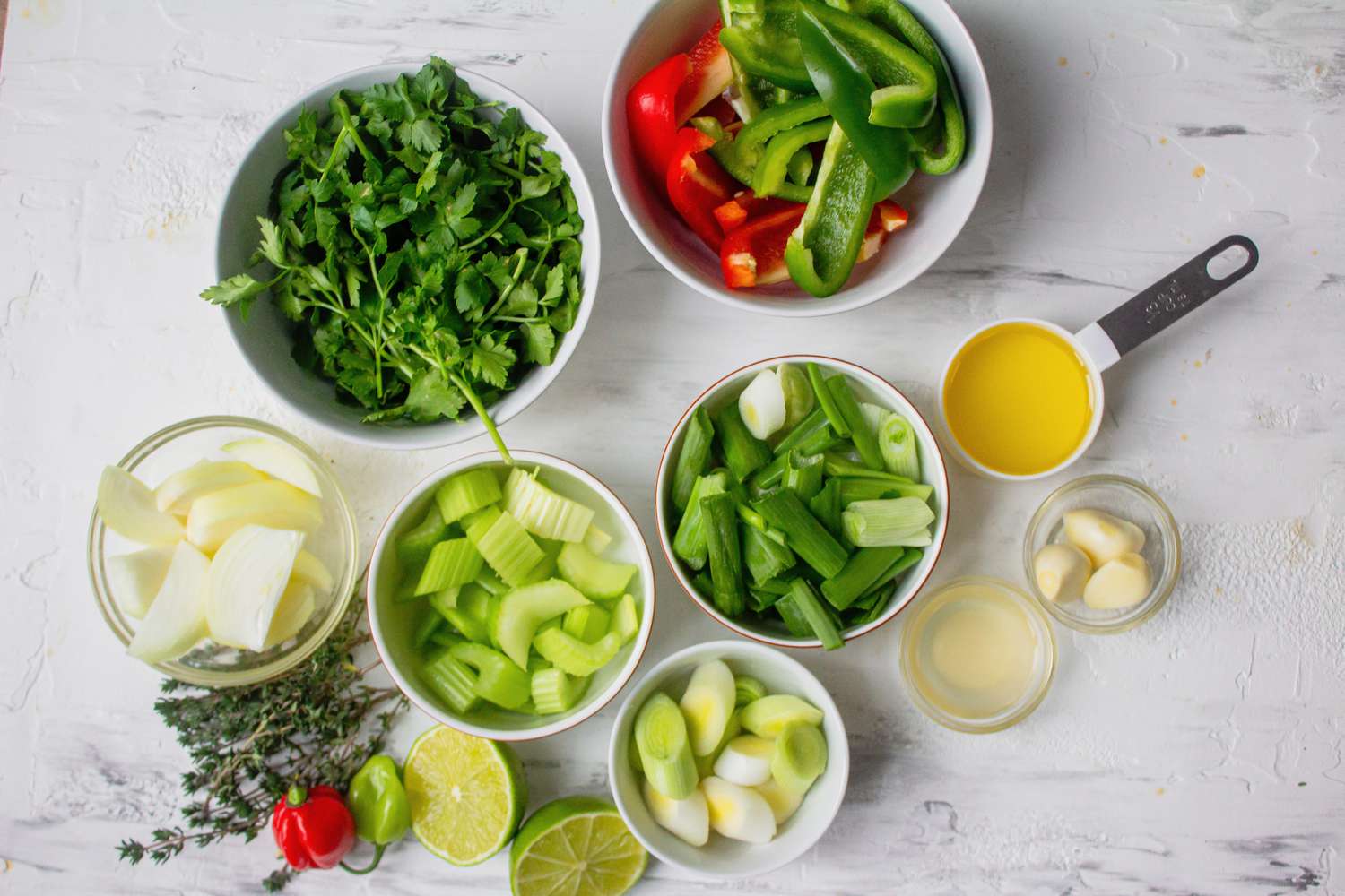 Cut onion, bell peppers, celery, and leeks for Haitian epis recipe