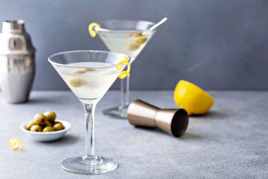 Two classic martinis with olives and lemon peel as garnish