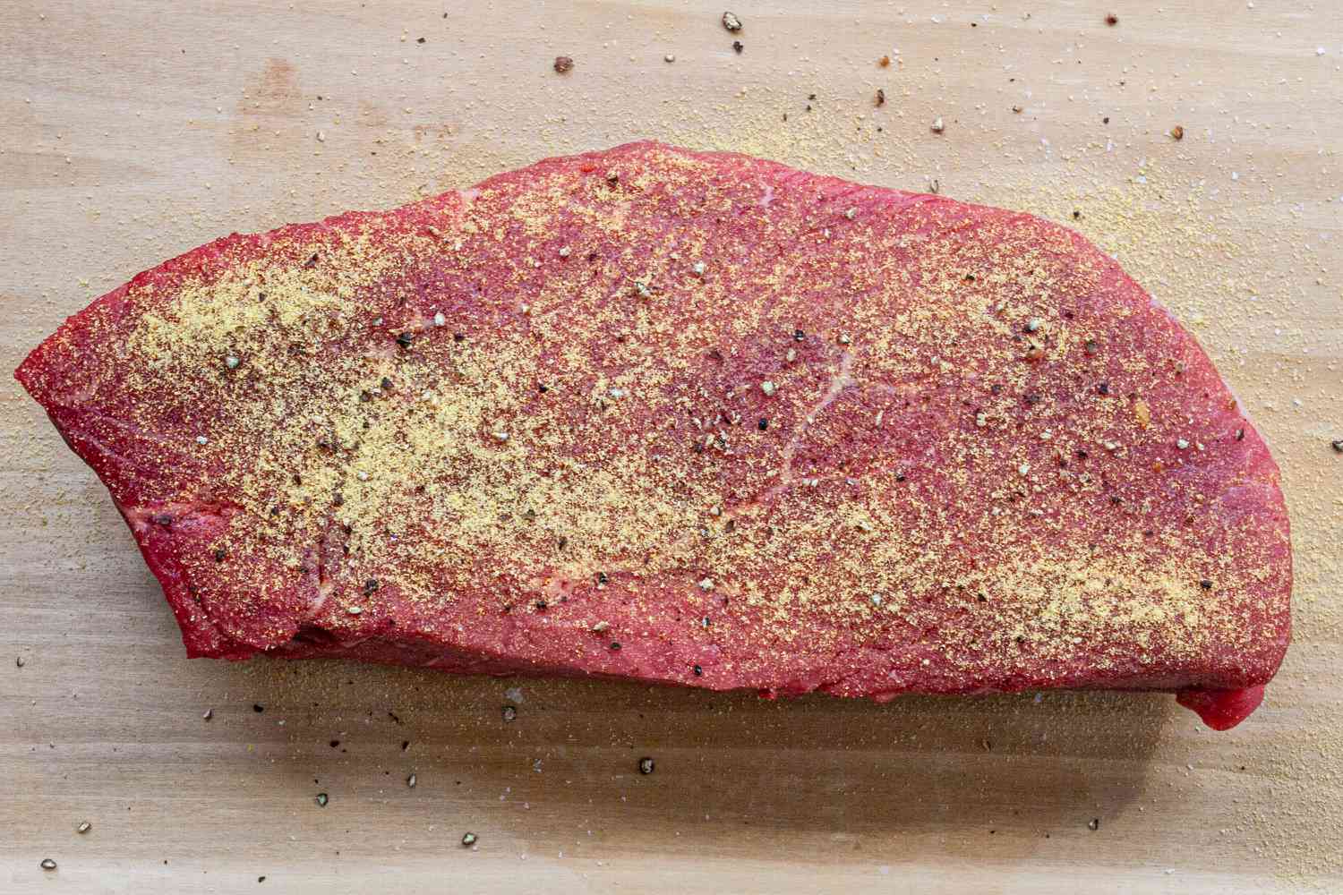 Seasoning steak to show how to cook london broil.