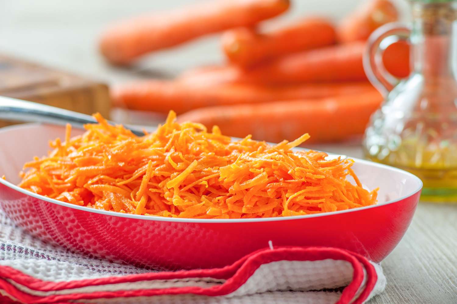 Grated carrots in a red bowl