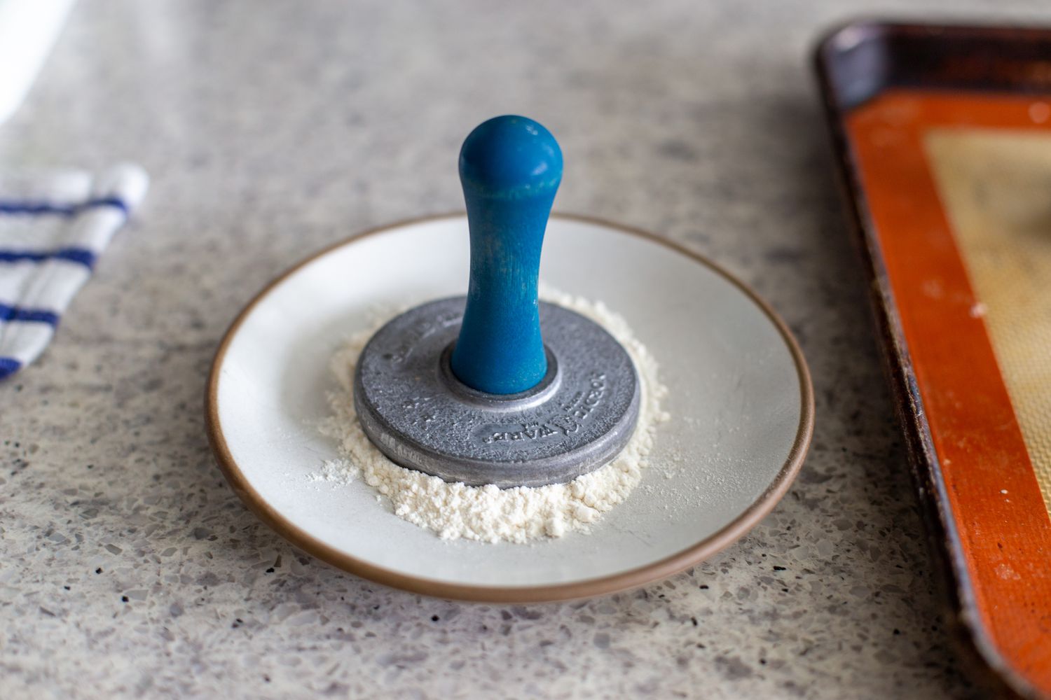 Stamp for almond-flavored butter cookies pressed into flour.