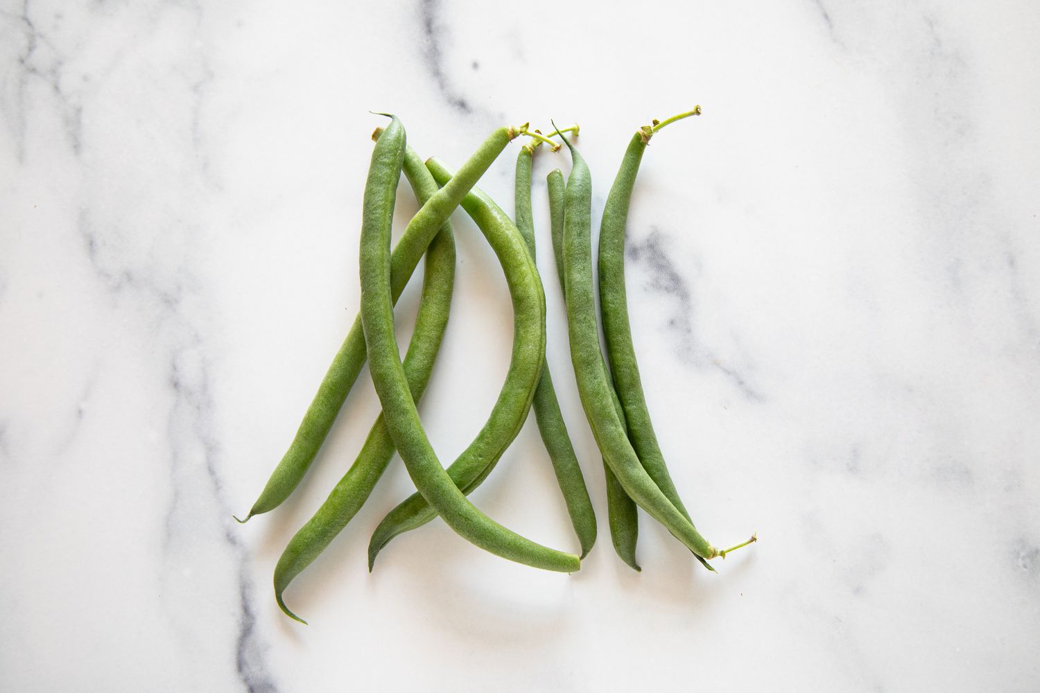 Green beans on a marble surface