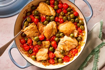 Overhead view of a blue dutch oven of tuscan-style chicken thighs recipe