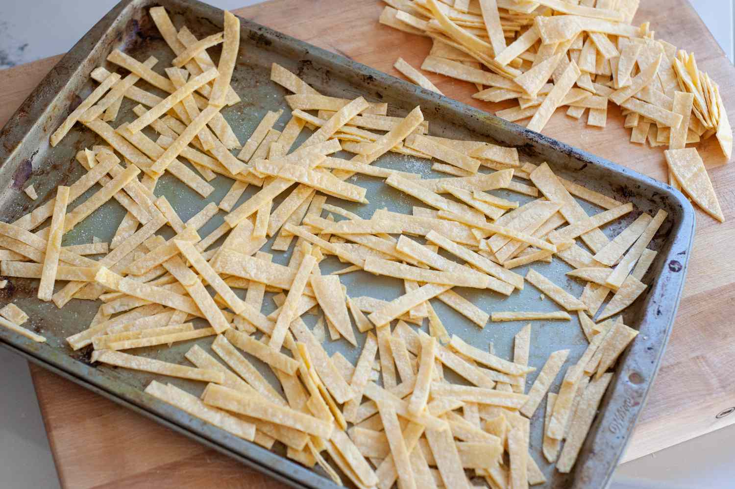 Tortilla strips on a baking sheet to make quick and easy vegetarian tortilla soup