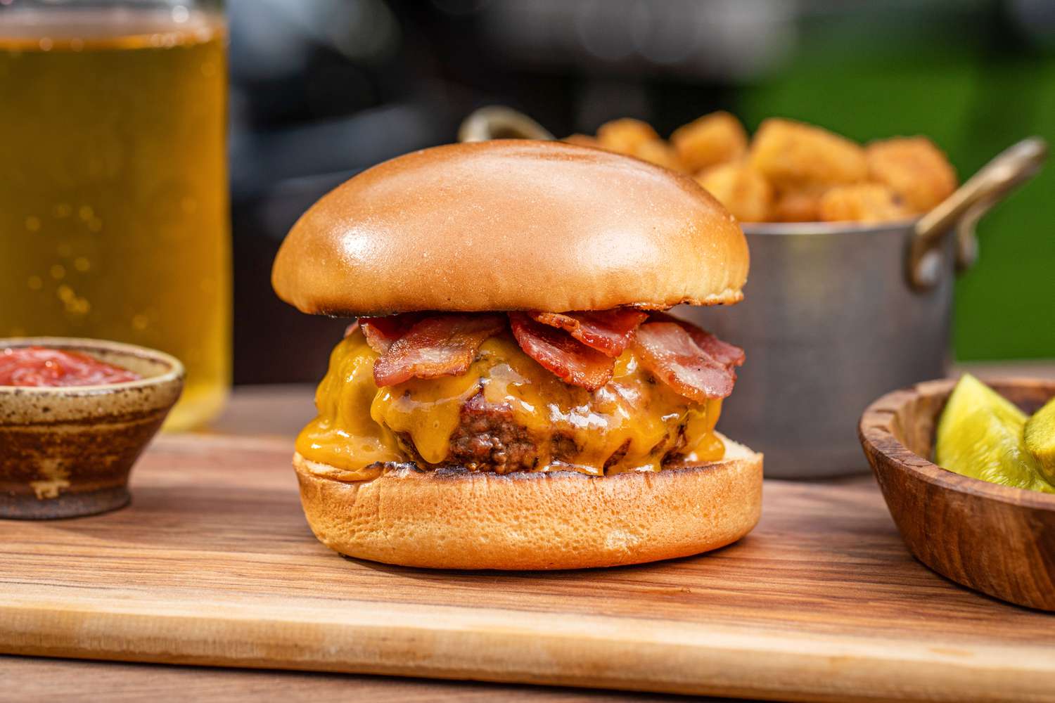 Best bacon cheeseburger set on a wood board outside.