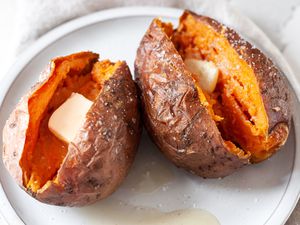 Plate with Microwave Sweet Potatoes Split in Half and Topped with a Slab of Butter and Salt 