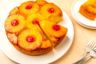Easy Pineapple Upside Down Cake on a plate, one slice removed, another slice cut