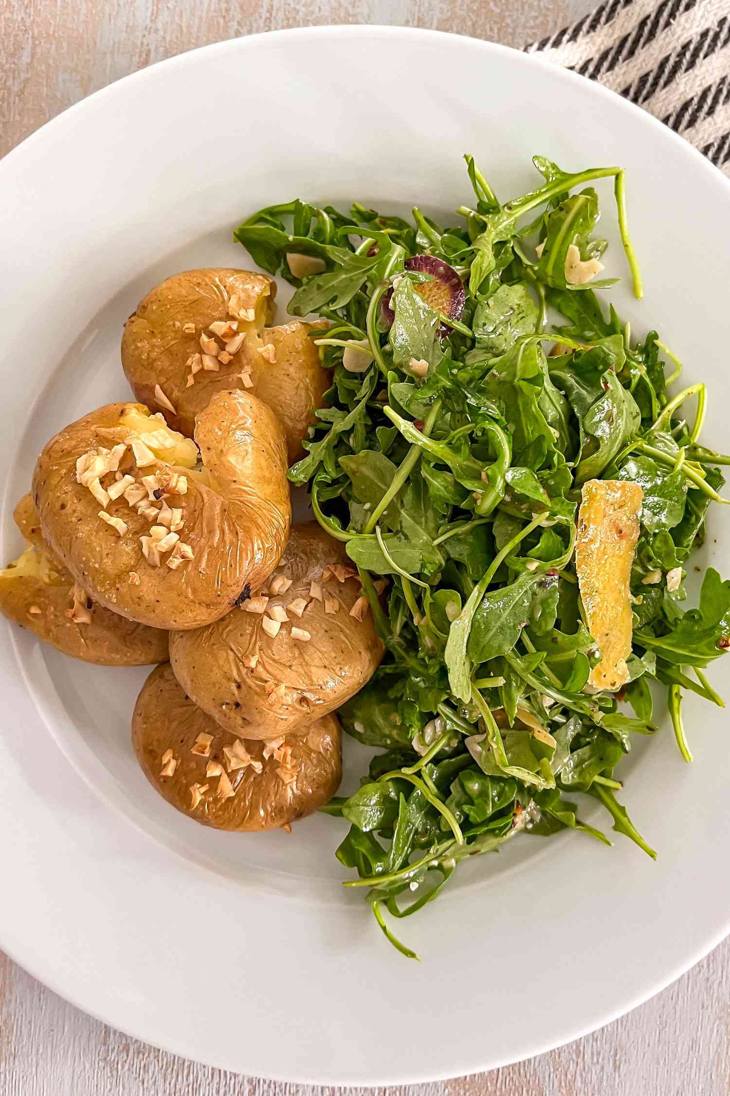 Plate of batatas a murro served with an arrugula side salad 