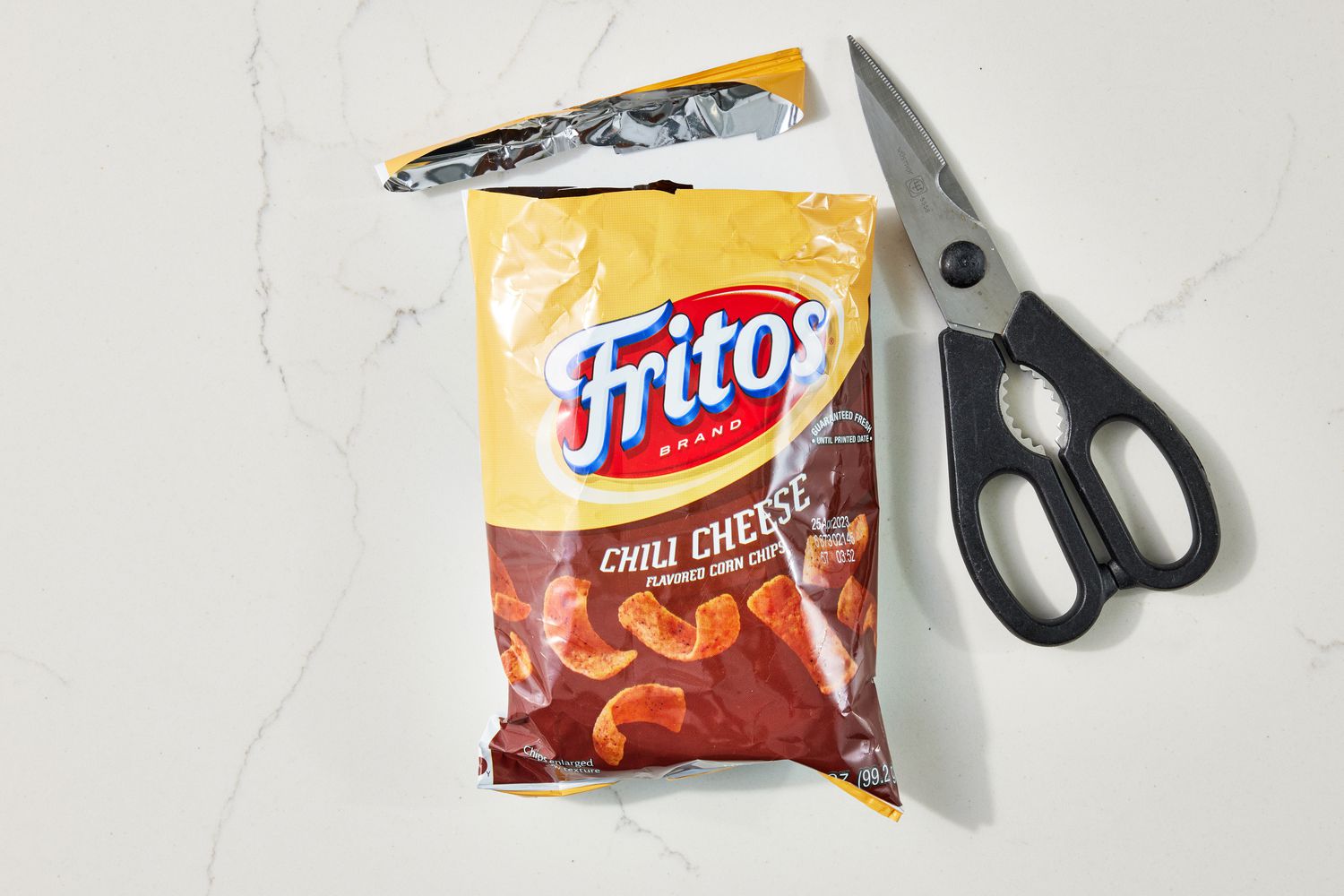 Bag of Fritos chips with the top cut open using a pear of shears for walking tacos