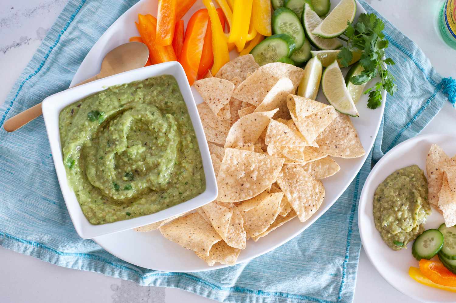 Bowl of Tomatillo Avocado Salsa on a Platter of Chips and Vegetables