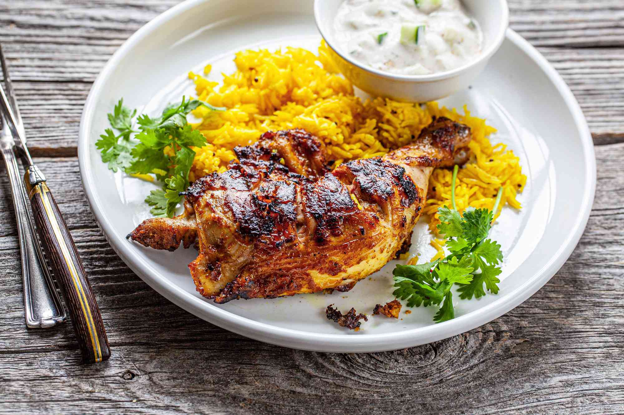 Tandoori Chicken with Turmeric Rice on Plate Next to Bowl of Raita