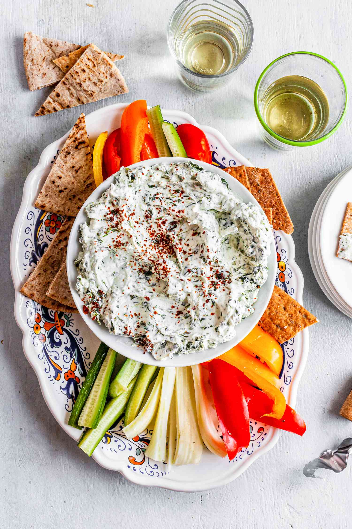 Bowl of Easy Spinach Dip Surrounded by Veggie Strips and Pita Triangles