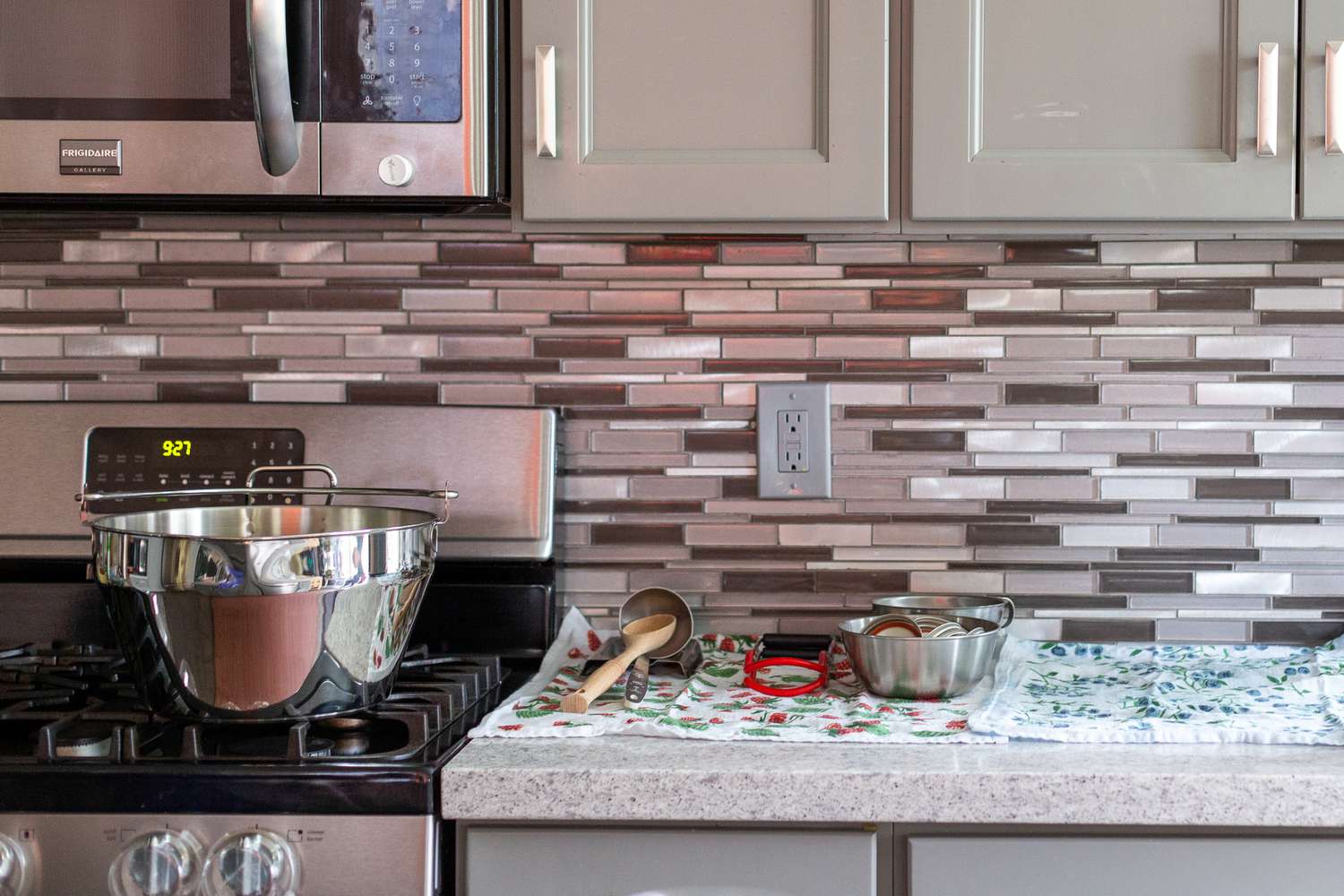 Kitchen Setting for Jam Canning: Countertop Covered with Kitchen Towels, Supplies Sitting on Top of Kitchen Towel, and on the Stove, a Big Pot for Boiling the Jam