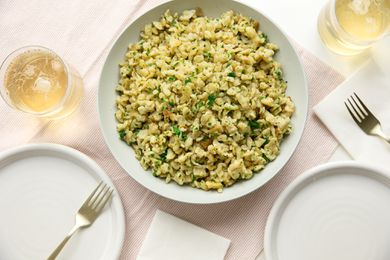 Bowl of Homemade Spaetzle (Spätzle) at a Table Setting with Two Drinks, Two Plates, and Forks on a Table Napkin