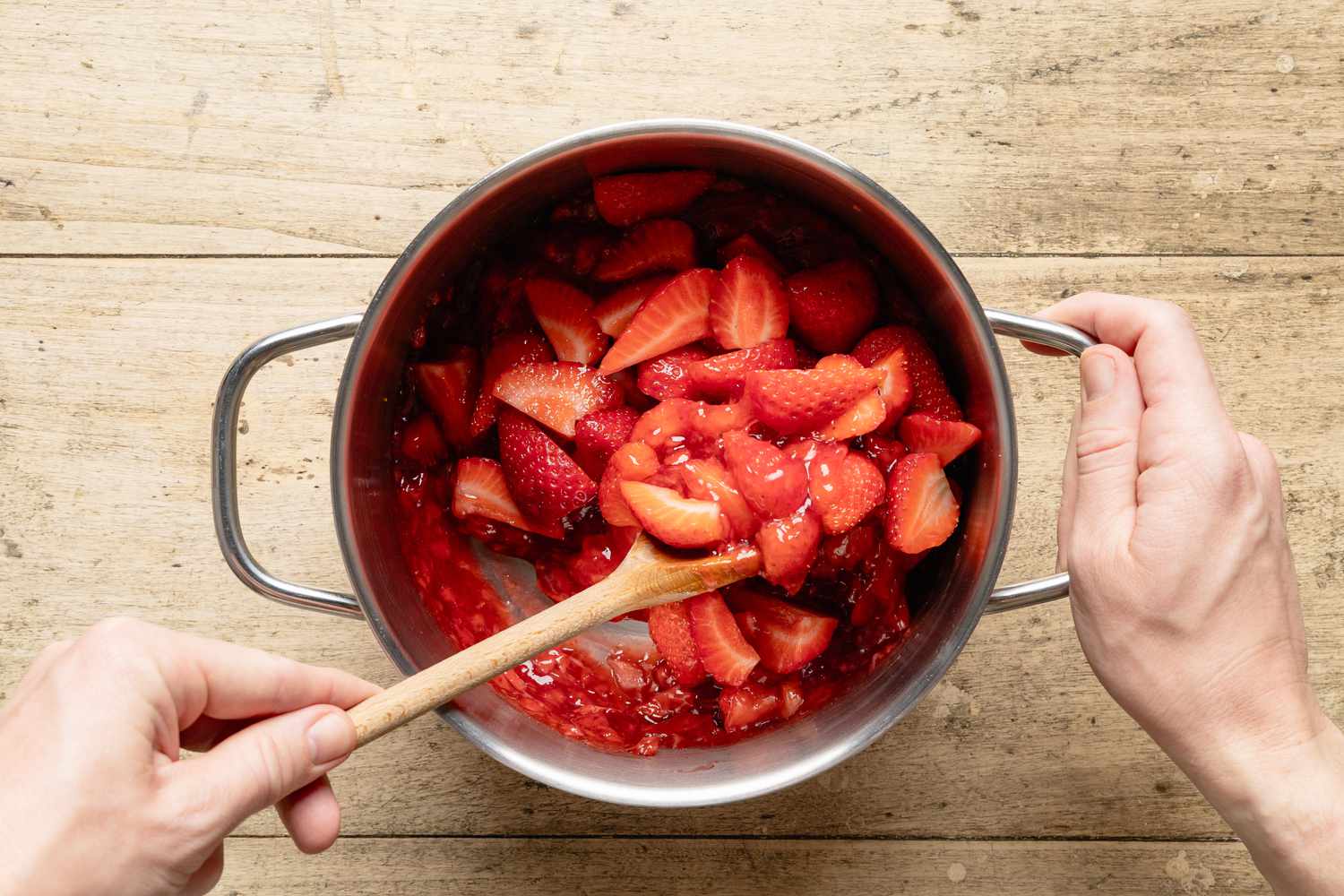 strawberry slices mixed into jammy strawberry filling in a pot for fresh strawberry pie recipe