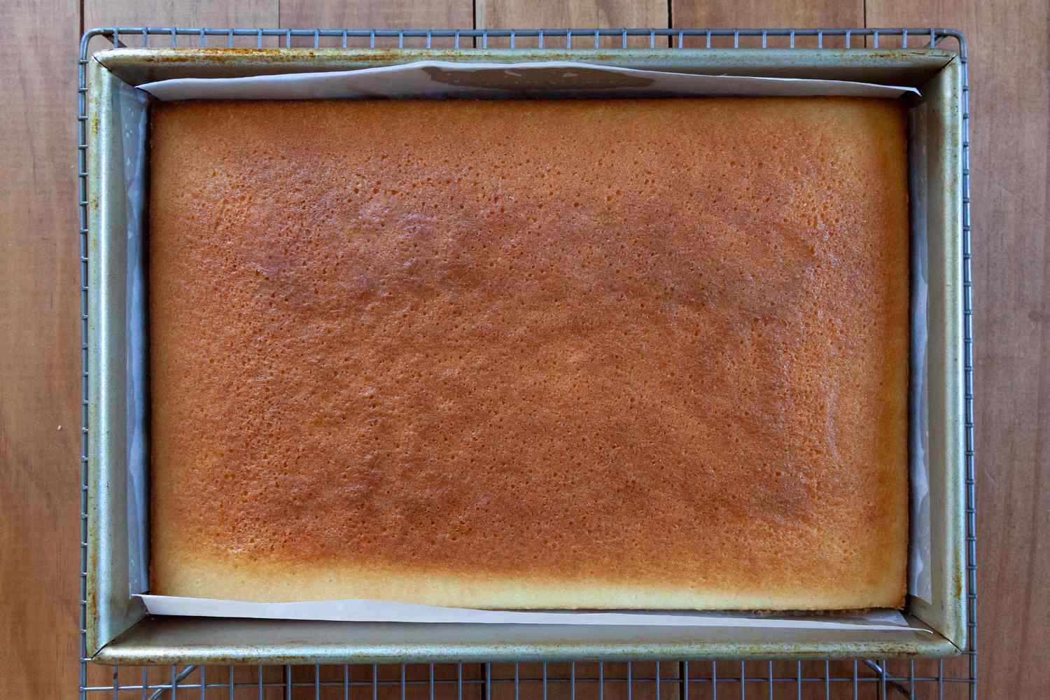 An easy white cake cooling on a rack.