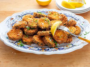 Fried Zucchini on a Platter with a Lemon Wedge and Fork