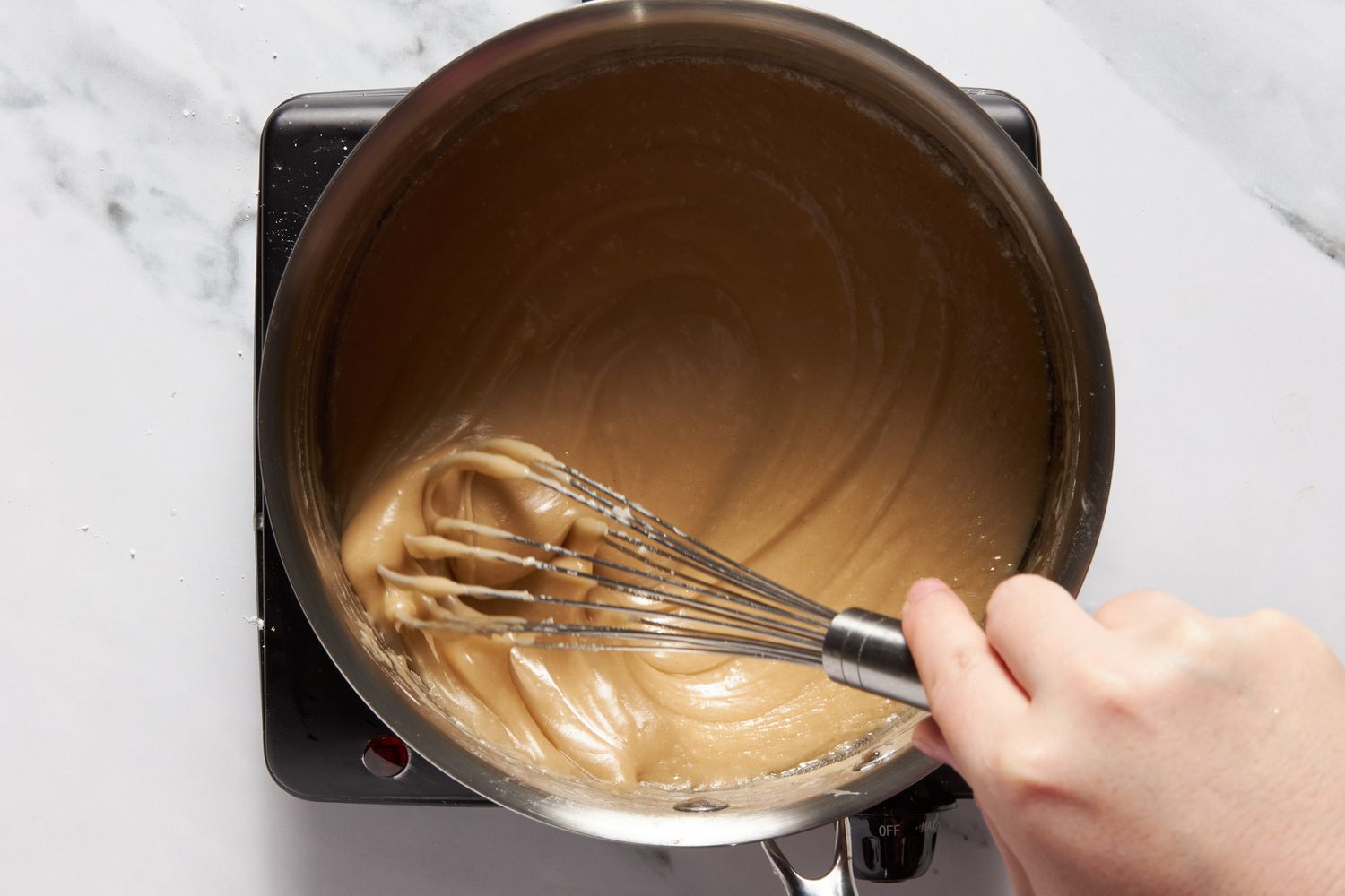 Dr. Pepper reduction whisked with powdered sugar until a caramel colored icing is made for Dr. Pepper cake recipe