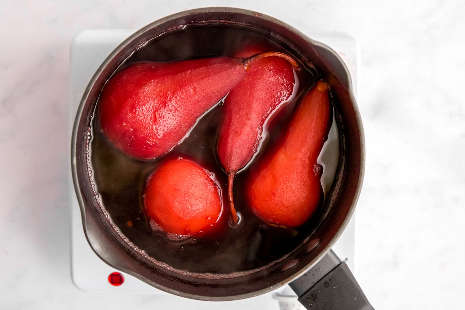 Four pears poached in red wine sauce. 