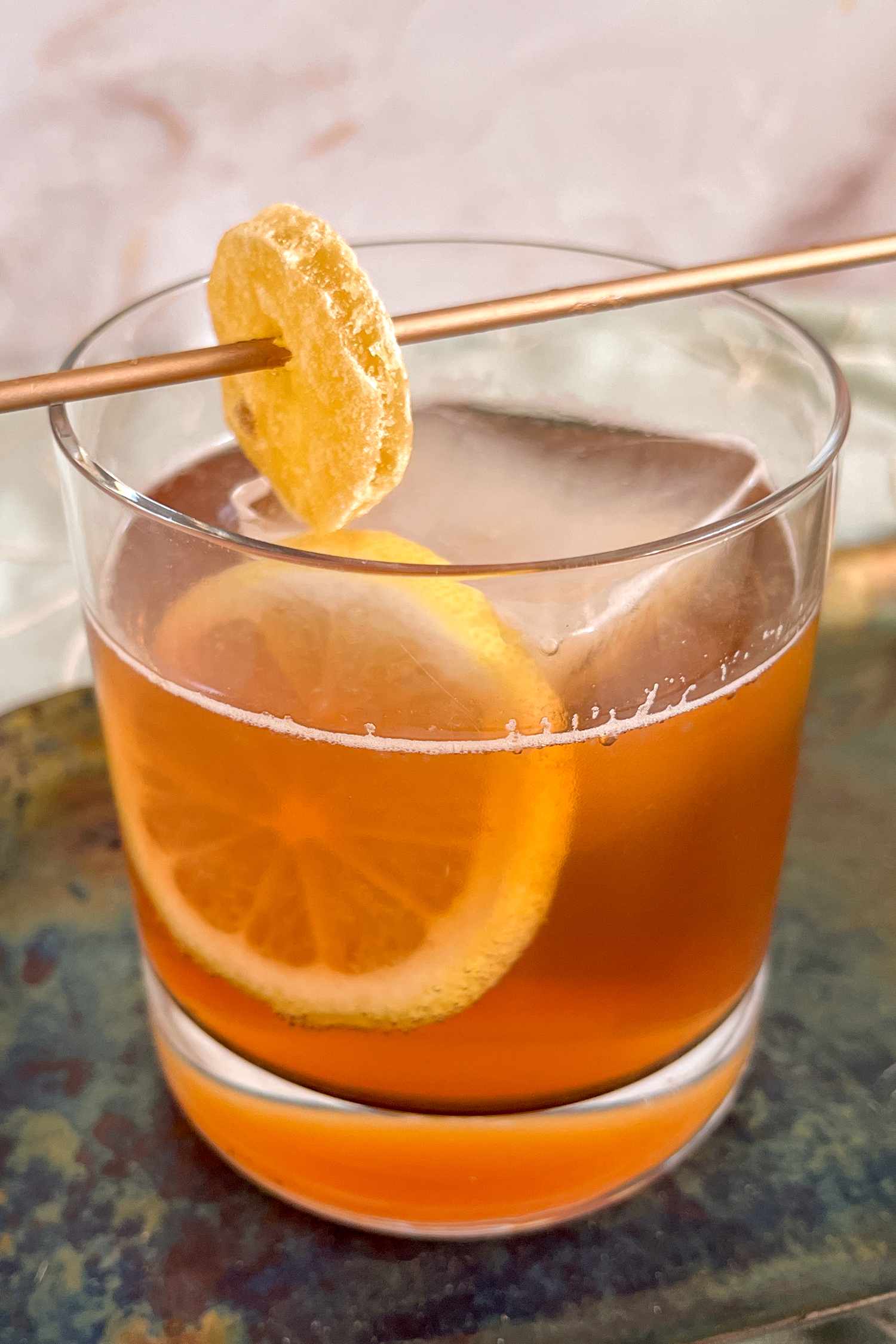 Autumn cocktail with a lemon wheel and candied ginger